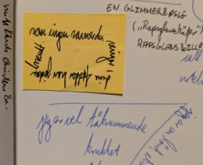 Orange sticky note with text: 'som ingen savner du vinger / dine fødder har jorden brændt.'