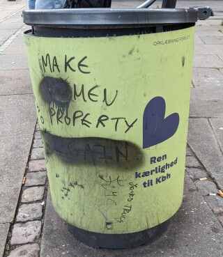 copenhagen trash can during pride with graffito 'make men property, which used to say 'make wo-men property' but was fixed by a good person who covered the 'wo'