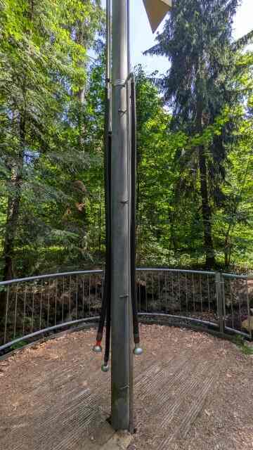 metal pillar in a forest on which tubes with funnels are attached; the top of the pillar has an analouge microphone/amplifier-like attachment. one can put the funnels onto ones ear to listen to the forest sounds