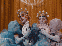 Two flamboyant persons in heavy white opera makeup, wearing cornblue dresses with puffy shoulders while holding white fans before their faces. They look very surprised, shocked even, as if they saw something truly transgressive.