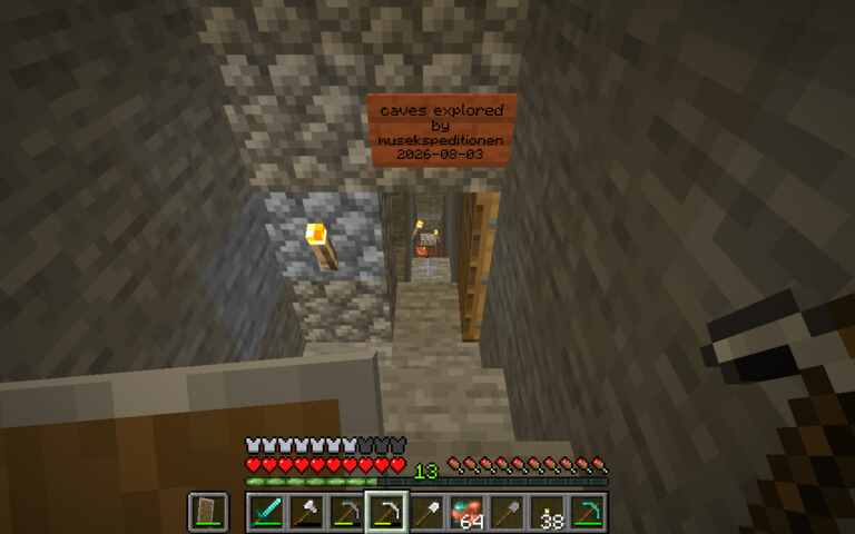 door entrance to caves with sign: mines explored by musekspeditionen 2026-08-03