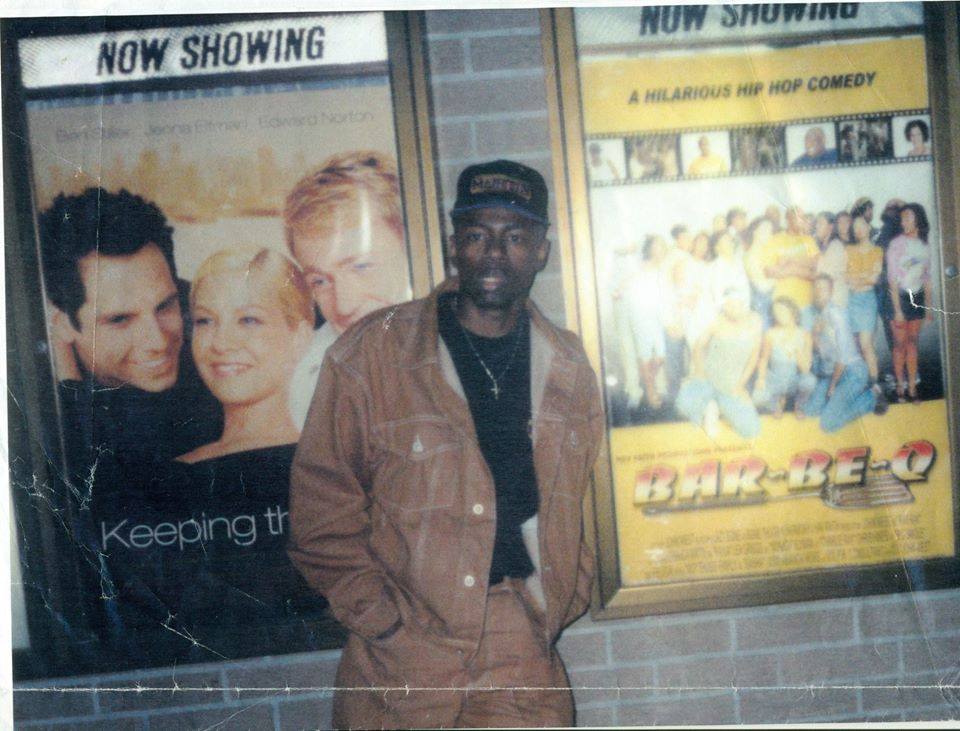 John West stands outside a cinema with a poster of Bar-Be-Q