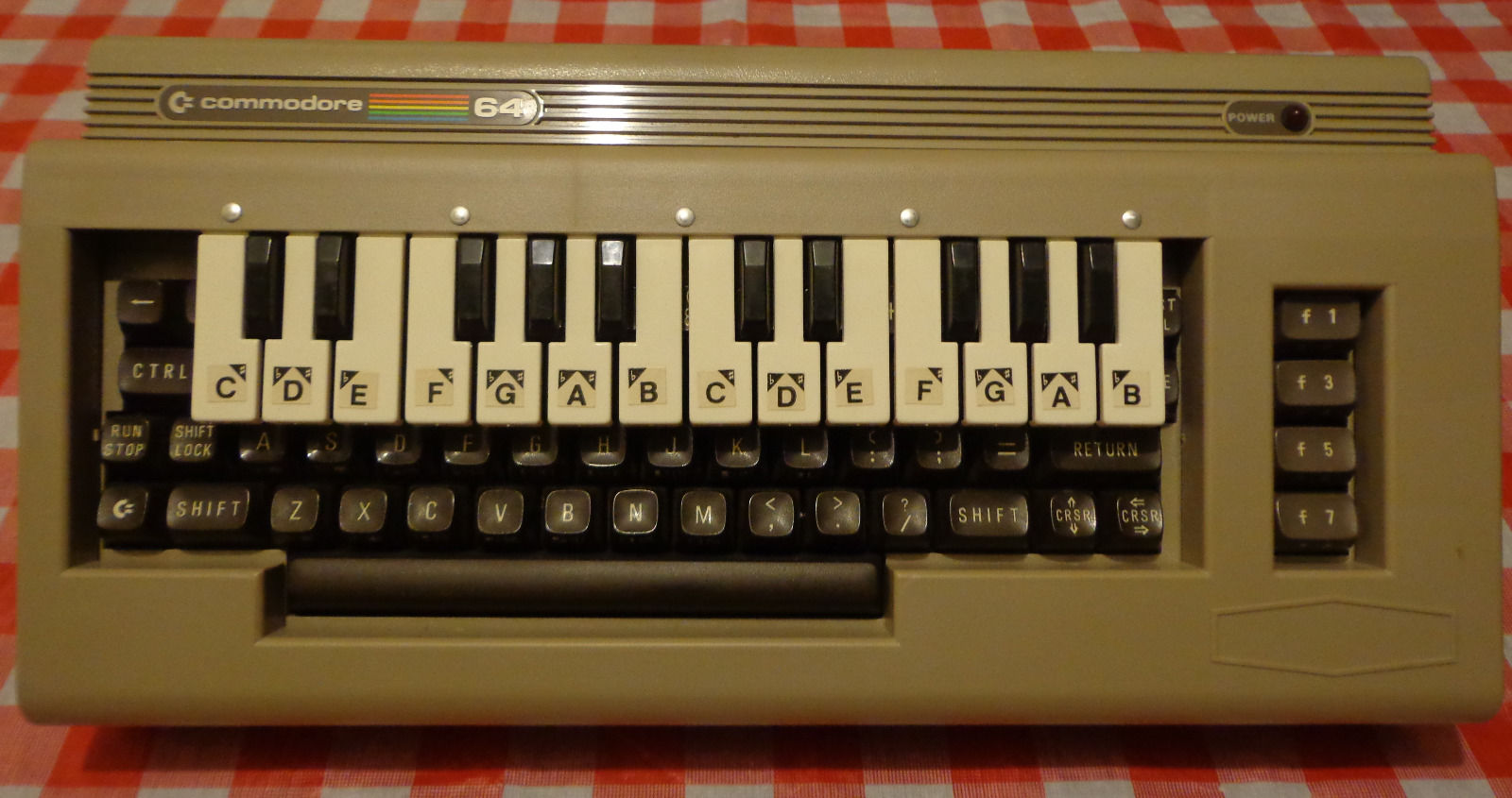 a plastic piano keyboard sitting atop a c64