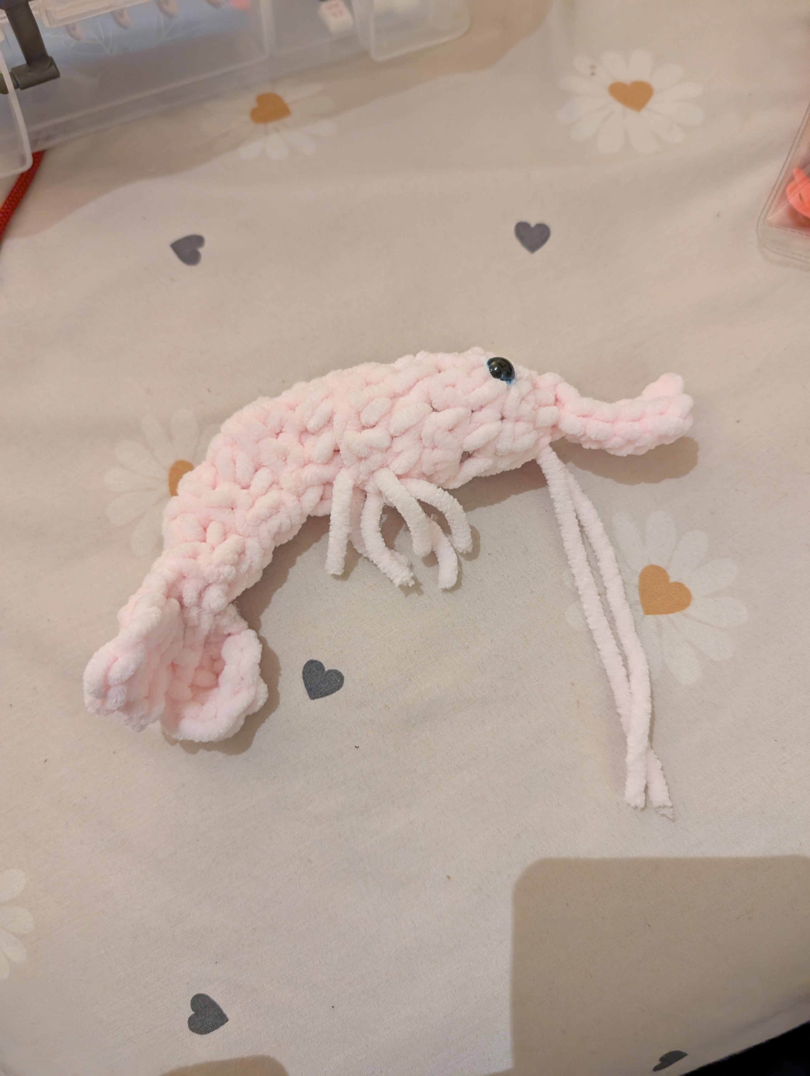 A photo of one large pale pink fluffy crocheted 
shrimp.